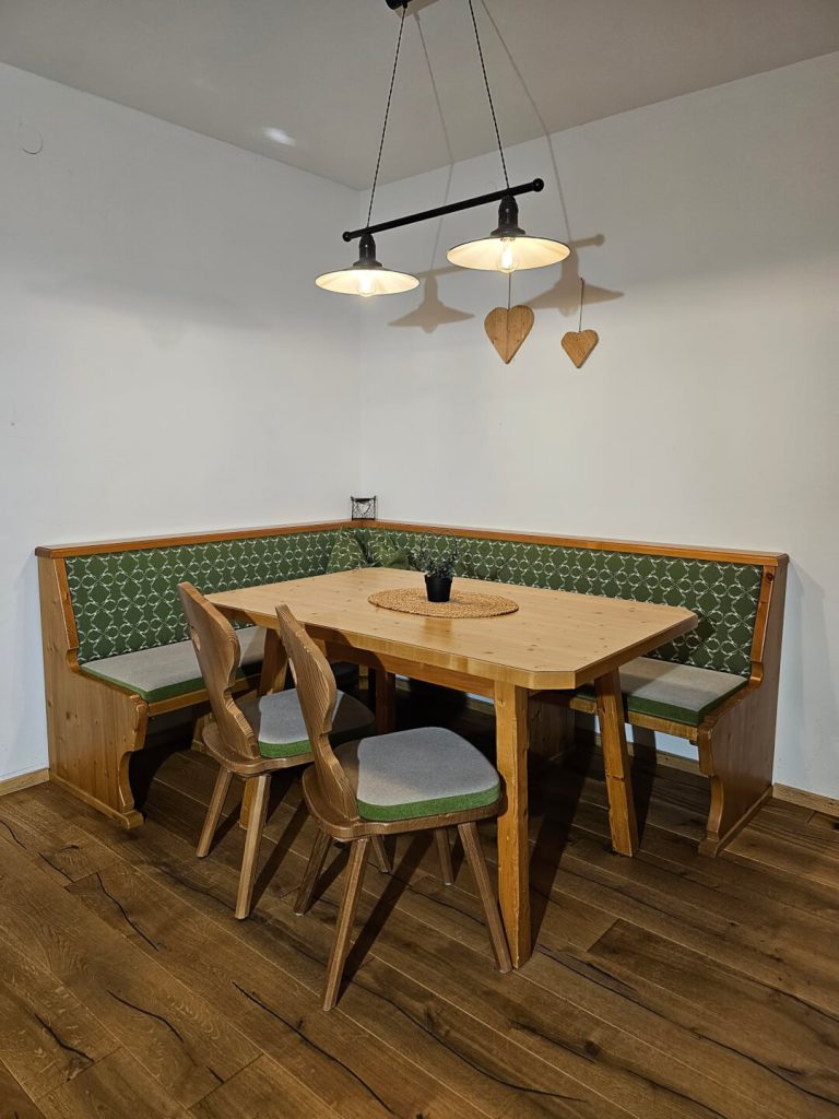 Gemütliche Essecke mit Holztisch und Bänken in alpiner Umgebung. Ideal für Familientreffen.