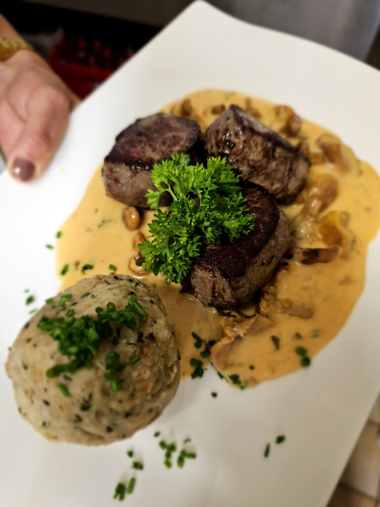 Traditionelles Gericht mit regionalen Produkten und Wildfleisch aus eigener Jagd im Restaurant Seestüberl des Hinterrohrguts in Flachau, Österreich.